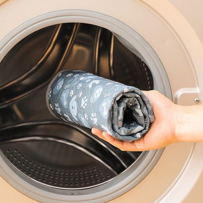 Person holding a washable dog potty pad folded fabric in front of an open washing machine with text about fabric durability.